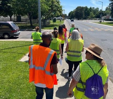 Group of people with neon vests walking on the sidewalk